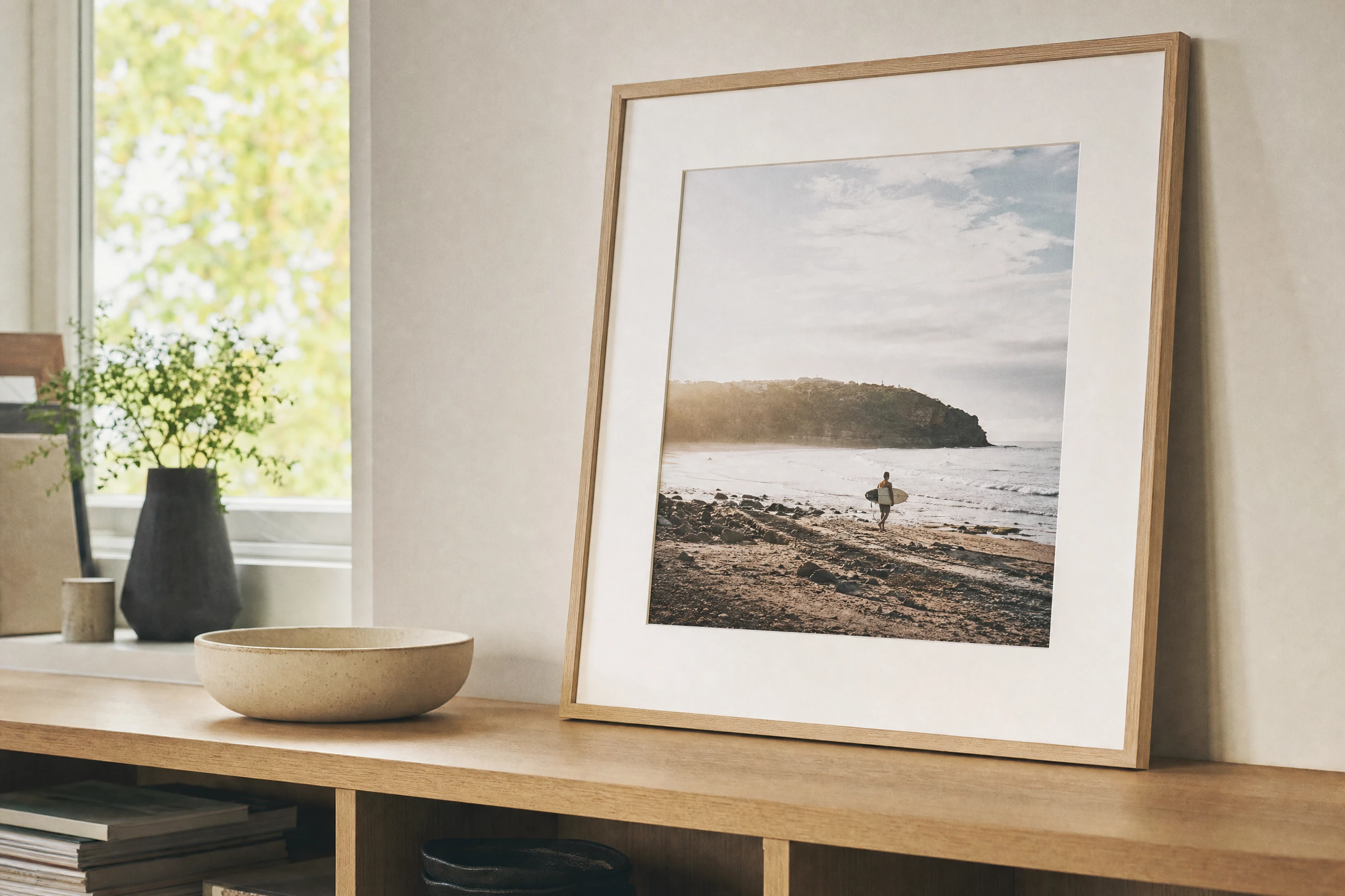 AI illustration of a framed coastal photograph standing on a wooden cabinet.